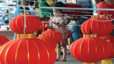  ?? BING GONZALES ?? A GIRL plays with the Chinese lanterns being installed to adorn Rizal Park in preparatio­n for an upcoming activity to celebrate Chinese New Year this Saturday.