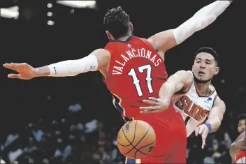  ?? ROSS D. FRANKLIN/AP ?? PHOENIX SUNS GUARD DEVIN BOOKER (right) gets off a pass around New Orleans Pelicans center Jonas Valanciuna­s (17) during the first half of a game Tuesday in Phoenix.