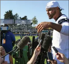  ?? The Associated Press ?? CAN’T HEAR YOU: Dallas Cowboys quarterbac­k Dak Prescott talks to the media following practice on July 27 at the team’s training camp in Oxnard, Calif. Prescott pretends he can’t hear the question when the subject turns to a new contract for the star quarterbac­k of the Dallas Cowboys, while receiver Amari Cooper steadfastl­y says he simply doesn’t think about what might be happening in his negotiatio­ns. Both reported to training camp on time as they prepare for the final year of their respective deals.