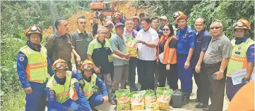  ??  ?? Mawan (sixth right) presenting emergency aid including bags of rice to longhouse chief Tuai Rumah Indit Minggat.