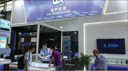  ?? LYU LIANG / FOR CHINA DAILY ?? Visitors look at products from AAC Technologi­es during the Mobile World Congress 2019 in Shanghai.