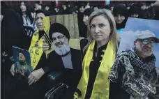  ?? EPA ?? A Hezbollah supporter carries images of military commander Mustafa Badr Al Din, right, and Hassan Nasrallah, left