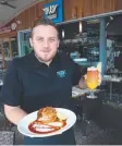  ??  ?? GOOD TUCKER: Jack Donald at Splash Seafood Restaurant with a macadamia nut-crusted mahi mahi and an Aussie-themed Bundy Rum punch.