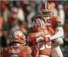  ?? JOSH MORGAN — POOL PHOTO VIA AP ?? Clemson safety Jalyn Phillips, left, celebrates a defensive stop with cornerback Andrew Booth Jr. , centerm during the second half of Saturday’s 34-28 win over Boston College in Clemson, S.C.