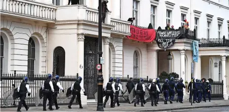  ?? Chris J Ratcliffe/Getty Images ?? Police officers in riot gear arrive after protesters occupied a building reported to belong to Russian oligarch Oleg Deripsaka in Belgrave Square, London