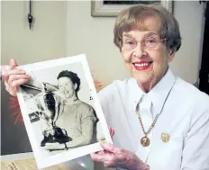  ?? TRIBUNE FILE PHOTO ?? Dorothy Rungeling, in this August 2008 photo, holds a picture of herself decades ago with her first-place trophy after winning the Governor General's Cup air race in Toronto.