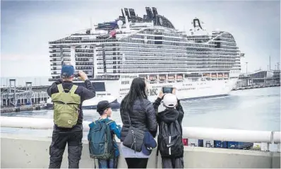  ?? Jordi Cotrina ?? Cuatro turistas contemplan un barco de la compañía MSC atracado en el Port de Barcelona.