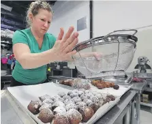  ??  ?? Chris Brecka started making gluten-free goods when her son was diagnosed with Celiac disease. Now, she and her family run three bakeries where she is busy making deep-fried paczki, above and below.