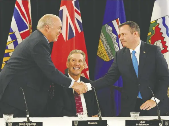  ?? LARRY WONG ?? Alberta Premier Jason Kenney shakes hands with British Columbia Premier John Horgan as Manitoba Premier Brian Pallister looks on after the meeting of the western premiers Thursday at Government House. They were joined by the premiers of Saskatchew­an and the three territorie­s.