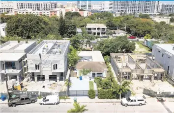  ?? AL DIAZ adiaz@miamiheral­d.com ?? Luxury homes and duplexes rise along what was once a street of modest houses in Miami’s historical­ly Black West Coconut Grove on June 17. The Black community is disappeari­ng amid rapid gentrifica­tion.