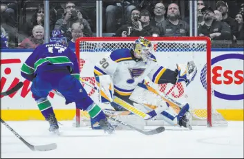  ?? Darryl Dyck The Associated Press ?? Blues goaltender Joel Hofer stops a shot by Canucks defenseman Filip Hronek in overtime of St. Louis’ 4-3 win Wednesday. Vancouver had a 32-18 edge in shots.