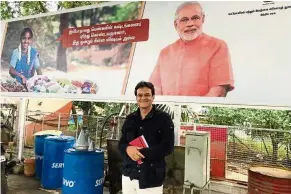  ??  ?? The columnist in front of a campaign billboard in India featuring Prime Minister Narendra Modi.