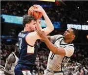  ?? Nick Wass/Associated Press ?? Georgetown guard Brandon Murray, right, battles for the ball against UConn’s Alex Karaban during the second half Saturday in Washington.