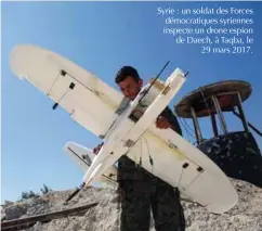  ??  ?? Syrie : un soldat des Forces démocratiq­ues syriennes inspecte un drone espion de Daech, à Taqba, le 29 mars 2017.