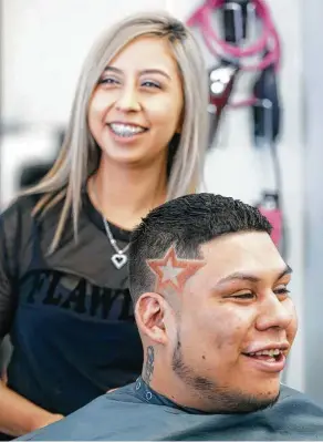  ?? Melissa Phillip / Houston Chronicle ?? Diana Martinez, owner of Studio Cutz Beauty &amp; Barber at 9461 Kempwood, and client Albert Sanchez share a laugh after she designed a star representi­ng the Astros logo.