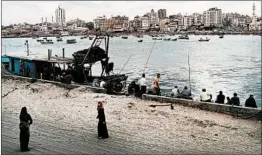  ?? SPENCER PLATT/GETTY ?? People walk and fish at the port Saturday in Gaza City, Gaza. Tensions are high along the Gaza-Israel border following more than a month of weekly mass protests near the fence.