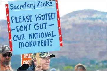  ?? George Frey Getty Images ?? CONSERVATI­ONISTS and Native Americans are among those fighting administra­tion plans to scale back national monuments. This protester helped others greet the Interior secretary last week in Kanab, Utah.