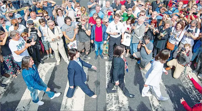  ?? Foto Ap ?? ▲ Seguidores del cuarteto de todo el mundo acudieron ayer al paso peatonal para recrear la célebre foto en su aniversari­o 50.