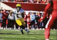  ?? Doug McSchooler / Associated Press ?? Michigan running back Blake Corum runs the ball out of the backfield during the second half against Indiana on Saturday in Bloomingto­n, Ind.