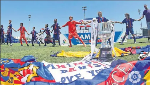  ??  ?? CAMPEONES. Los jugadores del Barcelona celebran, cogidos de la mano, su contundent­e triunfo en la final ante el Villarreal.