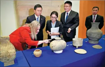  ?? LIU JIE / XINHUA ?? Hu Bing, deputy director of the National Cultural Heritage Administra­tion (second left) and Aleisha Woodward of the US State Department (left) examine on Thursday relics to be returned.