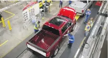  ??  ?? Workers inspect a Ford F-150 as it goes down the assembly line at Ford’s plant in Dearborn, Michigan.