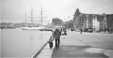  ??  ?? File photo on March 20, 2012 shows a man walking with a child near the marina in downtown Bergen, southweste­rn Norway. — Reuters photo