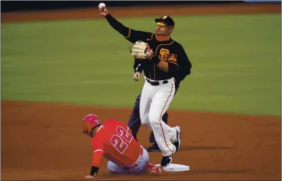  ?? JAE C. HONG — THE ASSOCIATED PRESS ?? San Francisco Giants second baseman Donovan Solano, top, throws to first base after forcing out Los Angeles Angels’ David Fletcher in the first inning of a spring baseball game in Scottsdale, Ariz., Sunday.