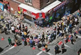  ?? Bebeto Matthews / Associated Press ?? Mourners gather Tuesday at a memorial outside a New York bodega where Lesandro Guzman-Feliz, 15, was slain in an apparent case of mistaken identity.