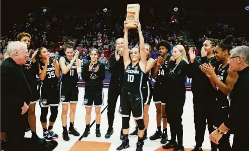  ?? Craig Mitchelldy­er / Associated Press ?? UConn’s Nika Muhl holds up the championsh­ip trophy after the Huskies beat Iowa on Sunday.