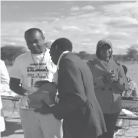  ??  ?? Mr Felix Silundika (centre) congratula­tes the overall winner and new record holder Emmanuel Dumani of Kungubo Village. His time was 50:40 mins