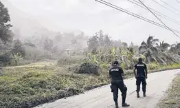  ?? ORVIL SAMUEL/AP ?? Police on Monday patrol a road to stop people from getting close to the active La Soufriere volcano.