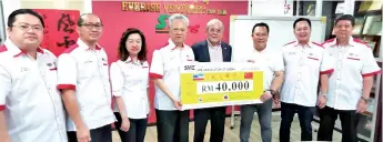  ??  ?? SME Sabah president Foo Ngee Kee (fourth left) hands over the associatio­n’s contributi­on of RM40,000 to Goh (fourth right).