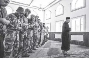  ?? AP/NARIMAN El-mofty ?? Former Mufti Sheikh Said ismahilov, leads Muslim soldiers during prayers on the first day of eid al-adha, in Medina Mosque, Konstantin­ovka, eastern Ukraine, on July 9.