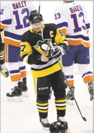  ?? Gene J. Puskar / Associated Press ?? The Pittsburgh Penguins’ Sidney Crosby skates off the ice with a puck after Game 4 of a first-round series against the New York Islanders on Tuesday.