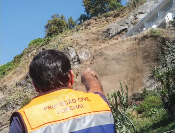  ?? ?? Os rocheiros estavam, ontem, a limpar a escarpa, sob o olhar atento de elementos do Governo e de hóspedes da unidade hoteleira.