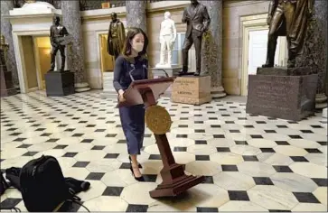  ?? Kent Nishimura Los Angeles Times ?? A LECTERN belonging to House Speaker Nancy Pelosi is moved through the Capitol’s Statuary Hall for a news conference after the impeachmen­t vote. The lectern was stolen during last week’s attack on the Capitol.