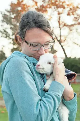  ?? ?? Volunteer Lauren Kurtz holds a 2-day-old “bottle baby” lamb, a mix of a Royal White ewe and a Katahdin sheep.