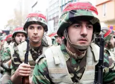  ??  ?? In this file photo shows members of Iran’s paramilita­ry Basij militia parade in front of the former US embassy in Tehran, to mark the national Basij week. — AFP photo
