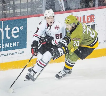  ?? BOB TYMCZYSZYN
THE ST. CATHARINES STANDARD ?? North Bay’s Braden Henderson (20) stick checks Niagara’s Philip Tomasino (26) in Ontario Hockey League action Friday night at Meridian Centre in St. Catharines.