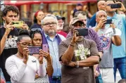  ?? PHOTOS BY STEVE SCHAEFER/FOR THE AJC ?? Members of the audience record the Soil Collection Ceremony conducted by the Gwinnett Remembranc­e Coalition in memory of the 1911 lynching of Charles Hale in Lawrencevi­lle.