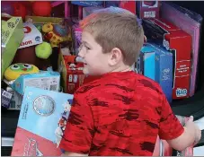  ?? MEGAN DAVIS/MCDONALD COUNTY PRESS ?? Seven-year old Stetson Curtis of Anderson grins ear to ear after choosing a Cars toy storage gift for himself and a gift for each of his brothers as well.