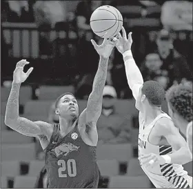  ?? File Photo/AP ?? Arkansas forward Darious Hall (20) and Connecticu­t forward Kwintin Williams reach for a rebound Nov. 26 during the Phil Knight Invitation­al in Portland, Ore.