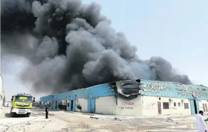  ?? Pawan Singh / The National ?? Smoke billows from one of the warehouses in the Sharjah industrial area yesterday, near National Paints.