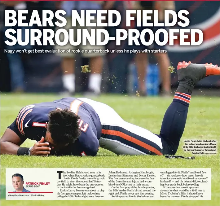  ?? NAM Y. HUH/AP ?? Justin Fields holds his head after his helmet was knocked off on a hit by Bills linebacker Andre Smith in the fourth quarter Saturday at Soldier Field.