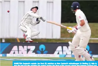  ?? —AFP ?? HAMILTON: England’s captain Joe Root (R) watches as New Zealand’s wicketkeep­er BJ Watling (L) fails to stop the ball and him reaching his century during day three of the second cricket Test between England and New Zealand at Seddon Park in Hamilton yesterday.