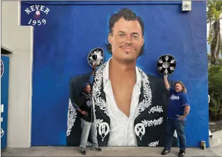  ?? DEAN MUSGROVE — STAFF PHOTOGRAPH­ER ?? Dodgers fans Dave Footman and Martin Schloemer from Redondo Beach pose at the Mariachi Joe Kelly mural by artist Jonas Never at Dodger Stadium. A Mariachi Joe Kelly bobblehead giveaway was Friday.