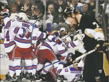  ?? Peter Diana/Post-Gazette ?? Paul Martin skates off the ice as the Rangers celebrate their overtime goal in Game 4, giving them a 3-1 edge in the first-round
series and a chance to clinch
Friday night at Madison Square
Garden.