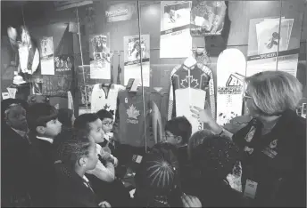  ?? CP PHOTO ?? Tour guide Linda Leahy takes a Grade 2 class through various exhibits at Canada’s Sports Hall of Fame in Calgary, Alta. This particular exhibit relates to the 2018 Pyeongchan­g Winter Olympics.