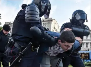  ??  ?? STRUGGLE: A protester is arrested and carried away by heavily armoured police